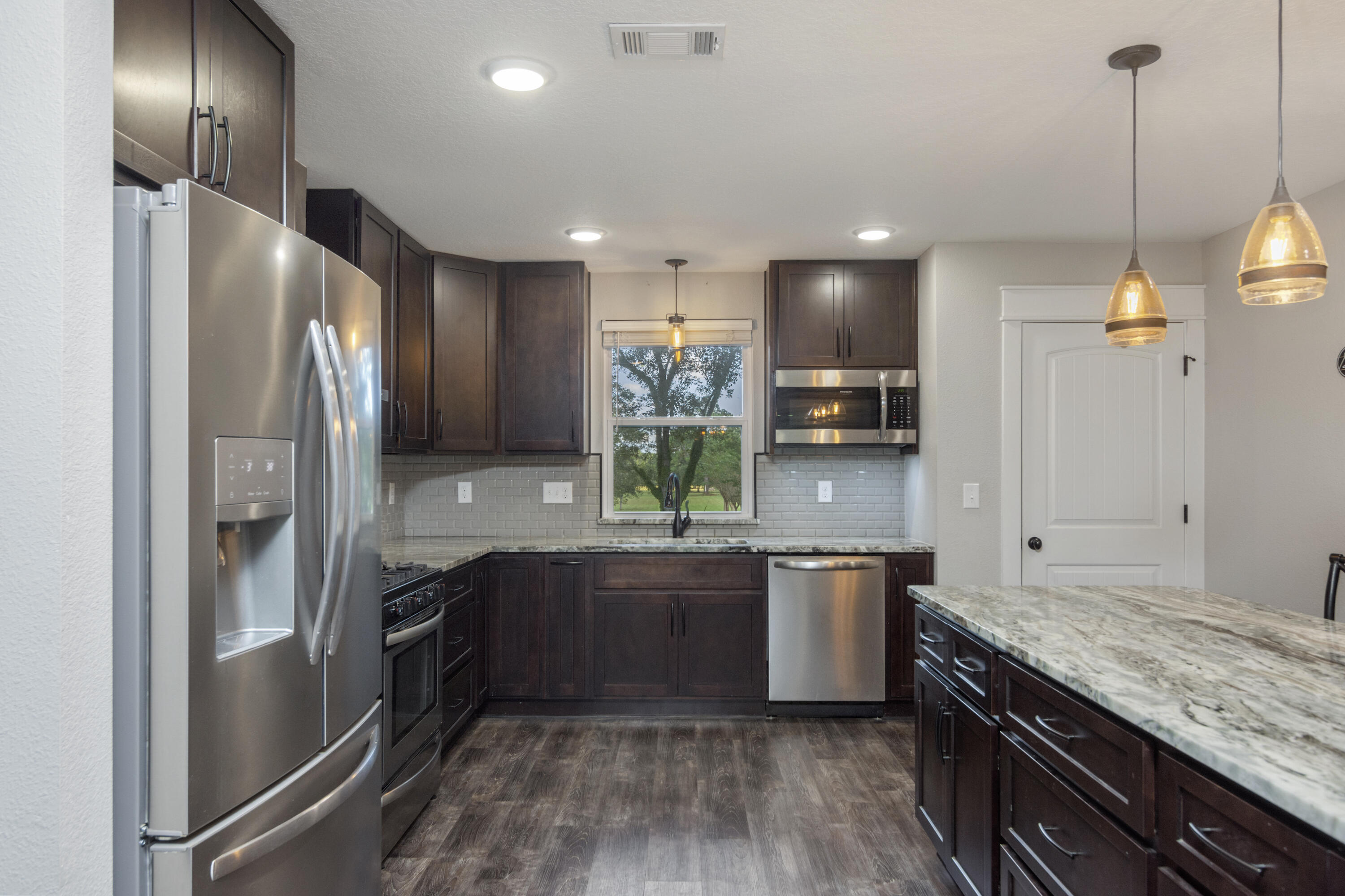 5822 Dairy Road Baker, FL 32531 - Photo 14 of 47 a kitchen with stainless steel appliances granite countertop a refrigerator a sink and a stove