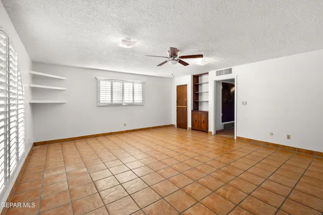 a bedroom with a bed a dresser and a large window