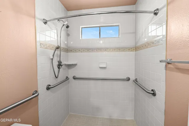 an empty room with wooden floor chandelier fan and windows