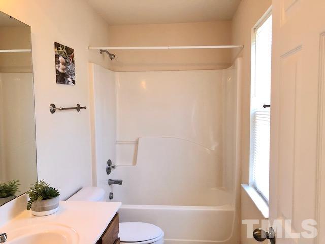 9810 Raleigh, NC 27617 - Photo 17 of 26 a bathroom with a bathtub shower sink vanity and toilet