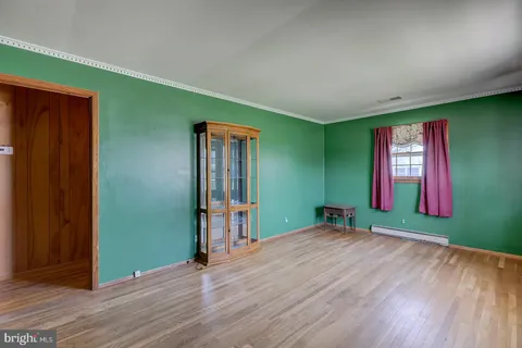 a view of a room with wooden floor and entryway