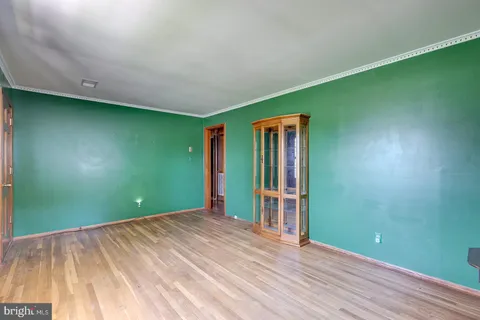 a view of empty room with window and wooden floor