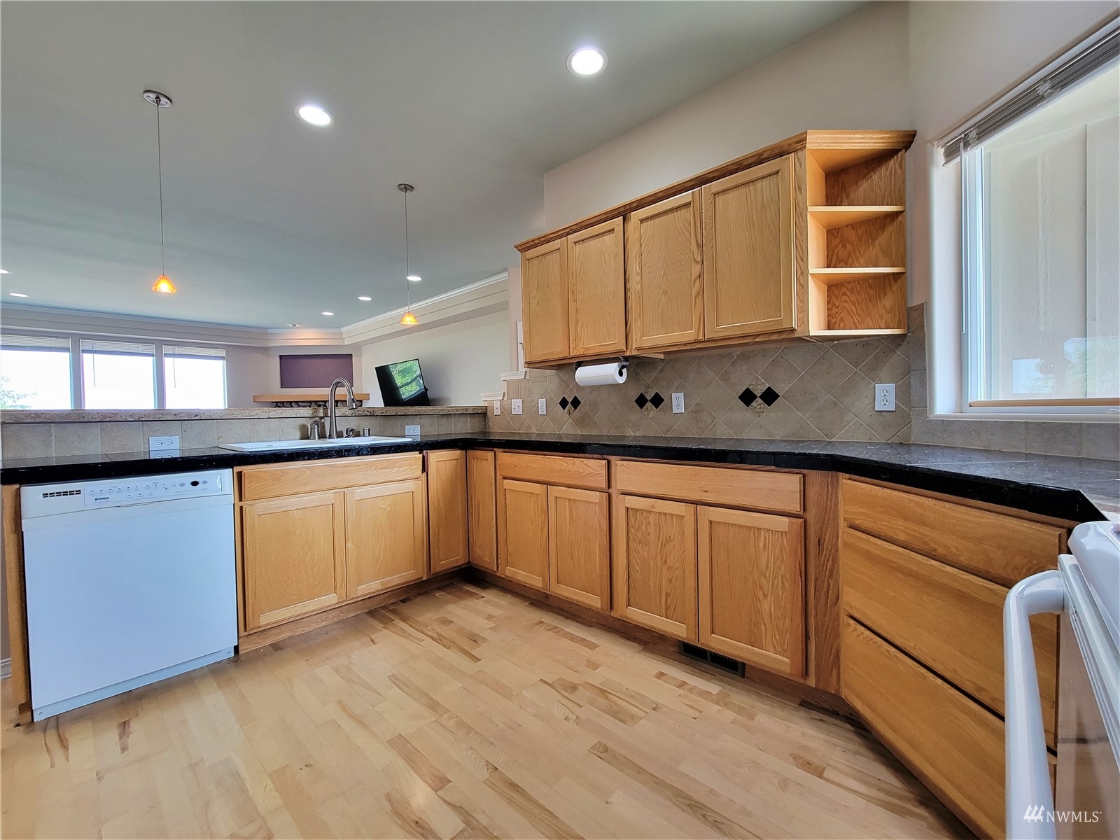 131 Les Saints Road Sequim, WA 98382 - Photo 11 of 32 a kitchen with stainless steel appliances granite countertop a sink cabinets and wooden floor