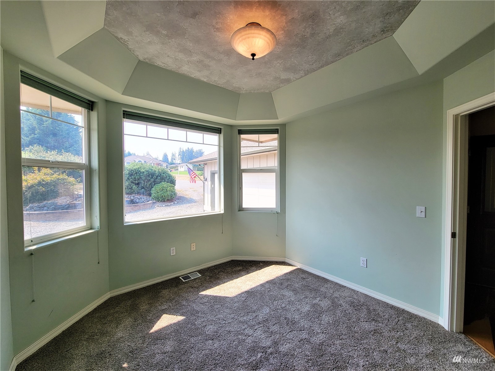 131 Les Saints Road Sequim, WA 98382 - Photo 7 of 32 an empty room with wooden floor and windows