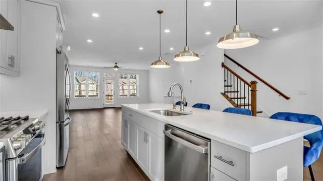 a kitchen with a sink a center island a stove and a chandelier