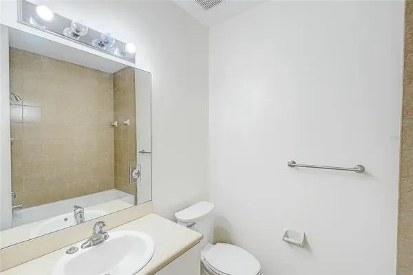 a bathroom with a sink mirror vanity and toilet