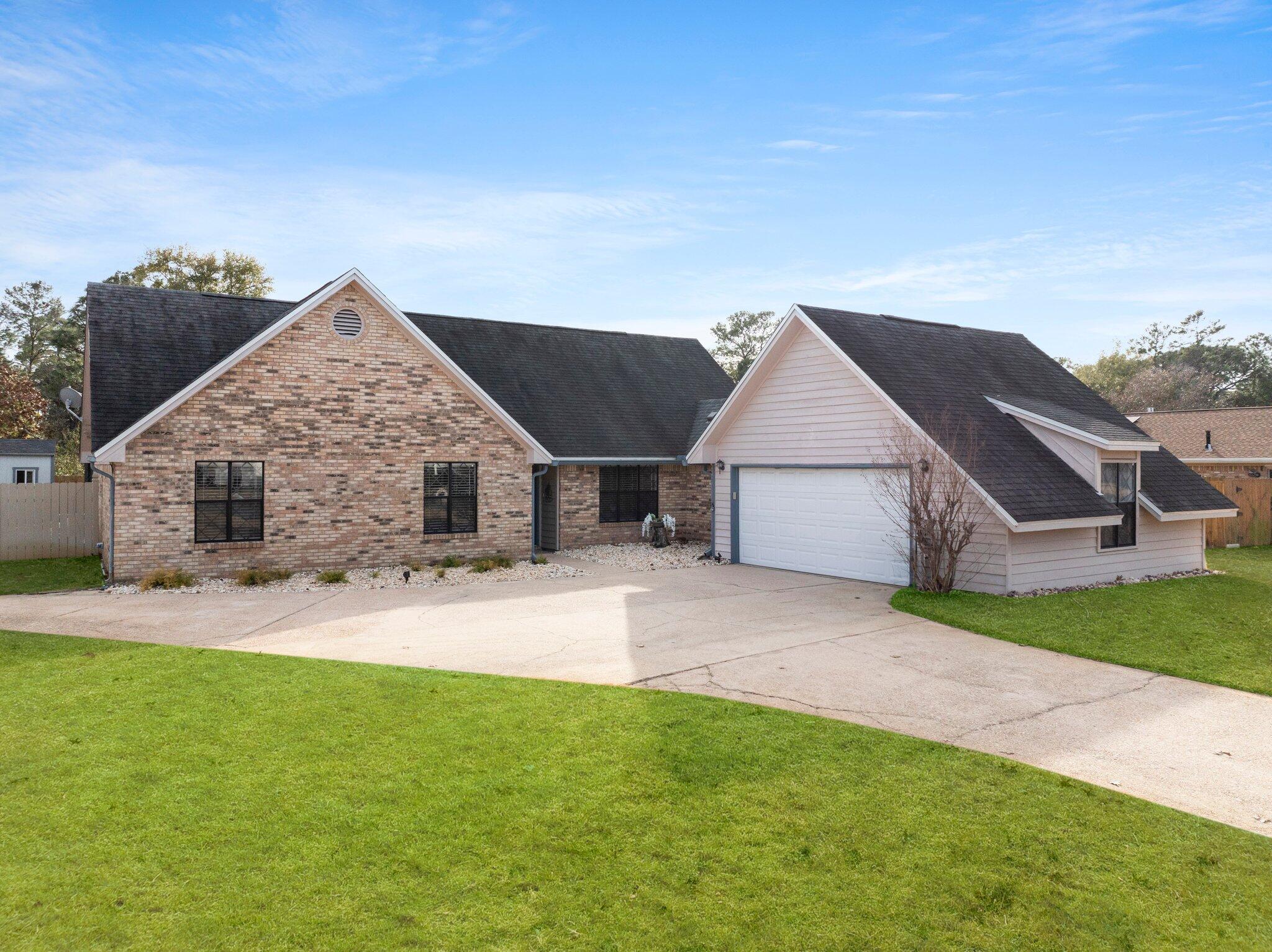 a view of house with backyard and a garden