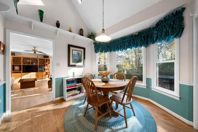 a dining room with furniture window and wooden floor