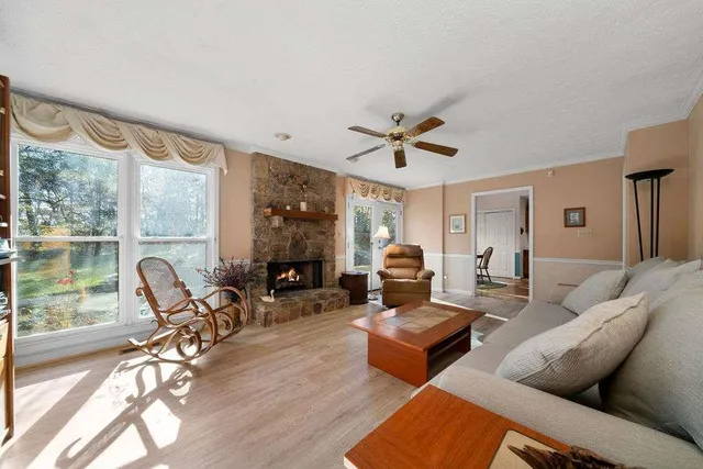 a living room with furniture a fireplace and a floor to ceiling window