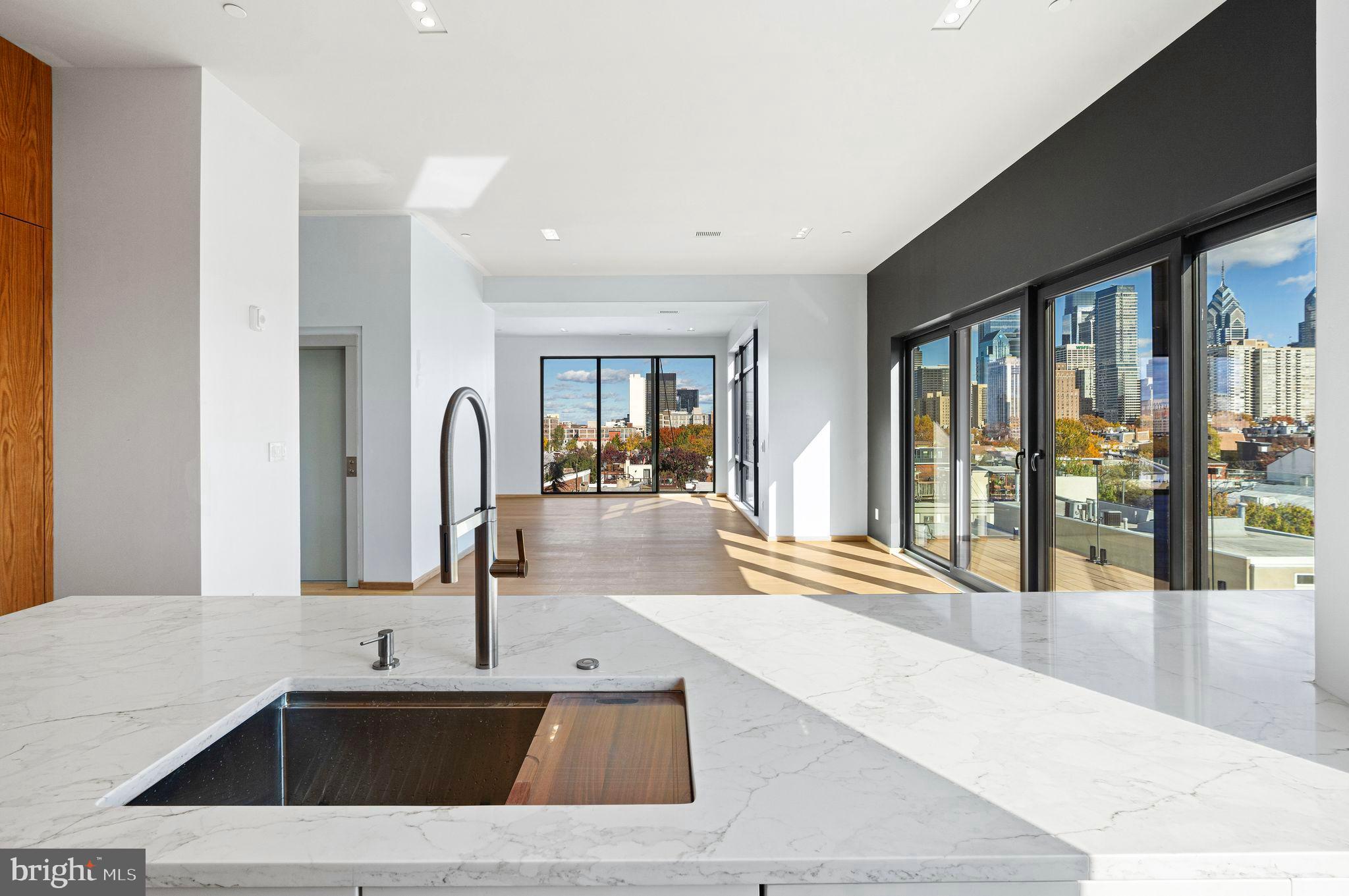 a kitchen with a sink and large mirror of open cabinet