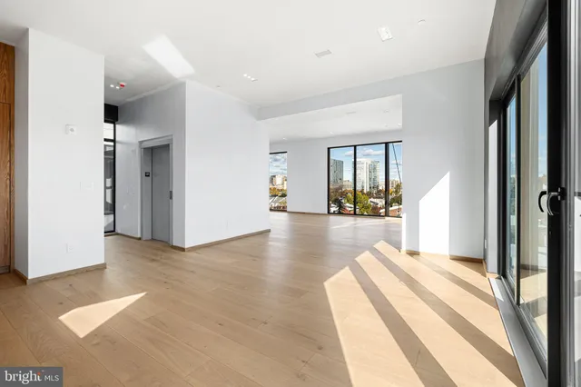 a view of a hallway with wooden floor and a large window