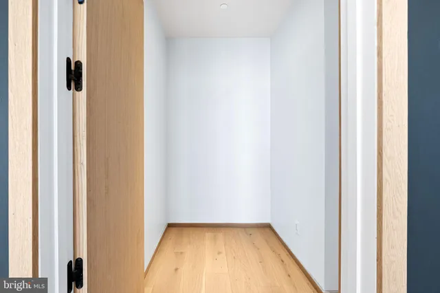 a view of a room with wooden floor and a small space