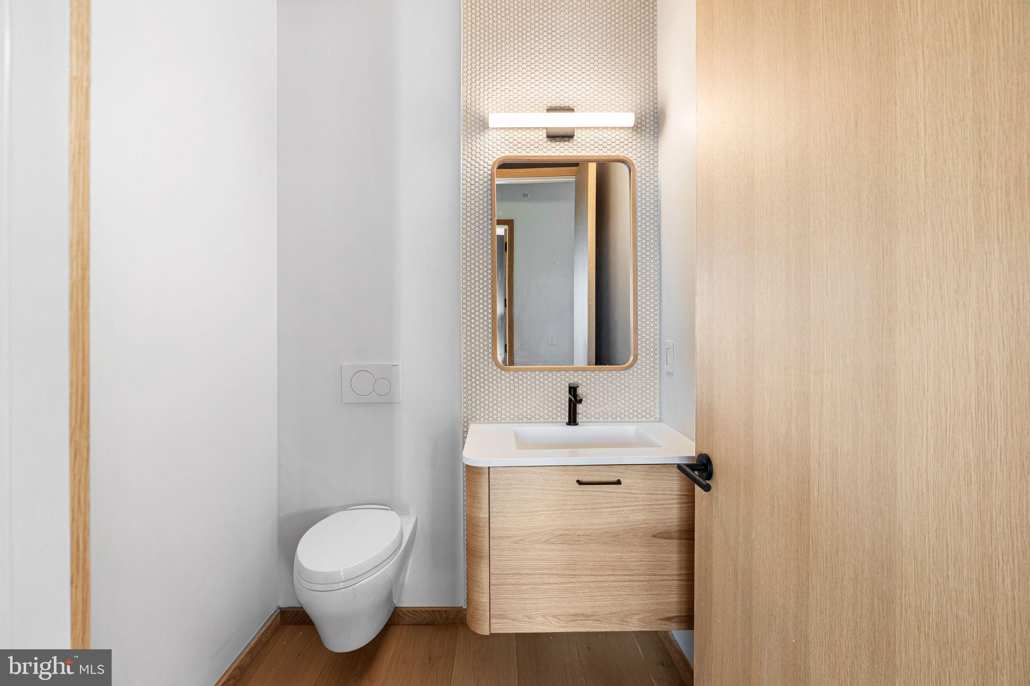 617 South 24th Street, Unit 501 Philadelphia, PA 19146 - Photo 34 of 36 a bathroom with a toilet sink and mirror