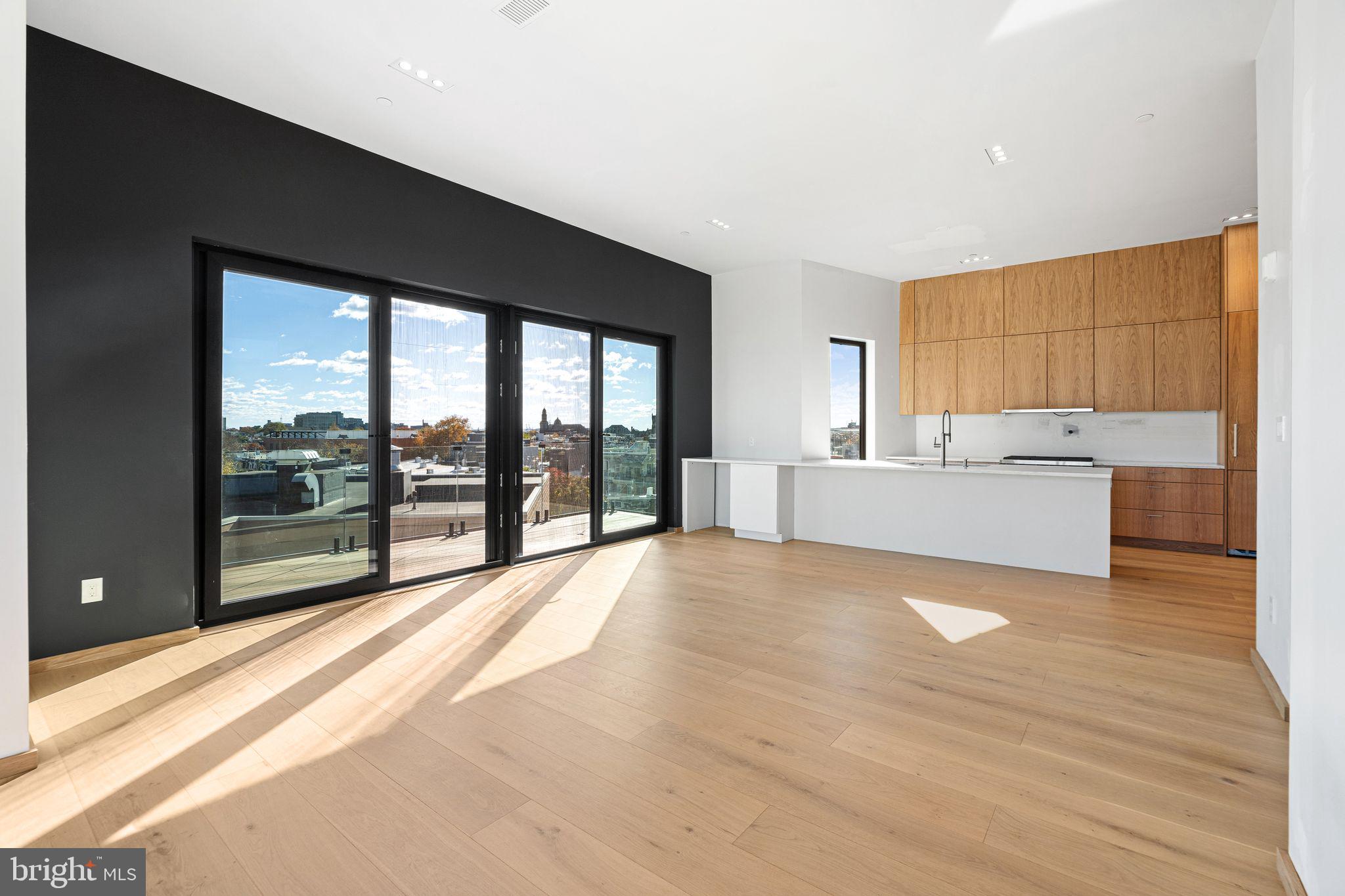 617 South 24th Street, Unit 501 Philadelphia, PA 19146 - Photo 7 of 36 a living room with a large window and a wooden floor