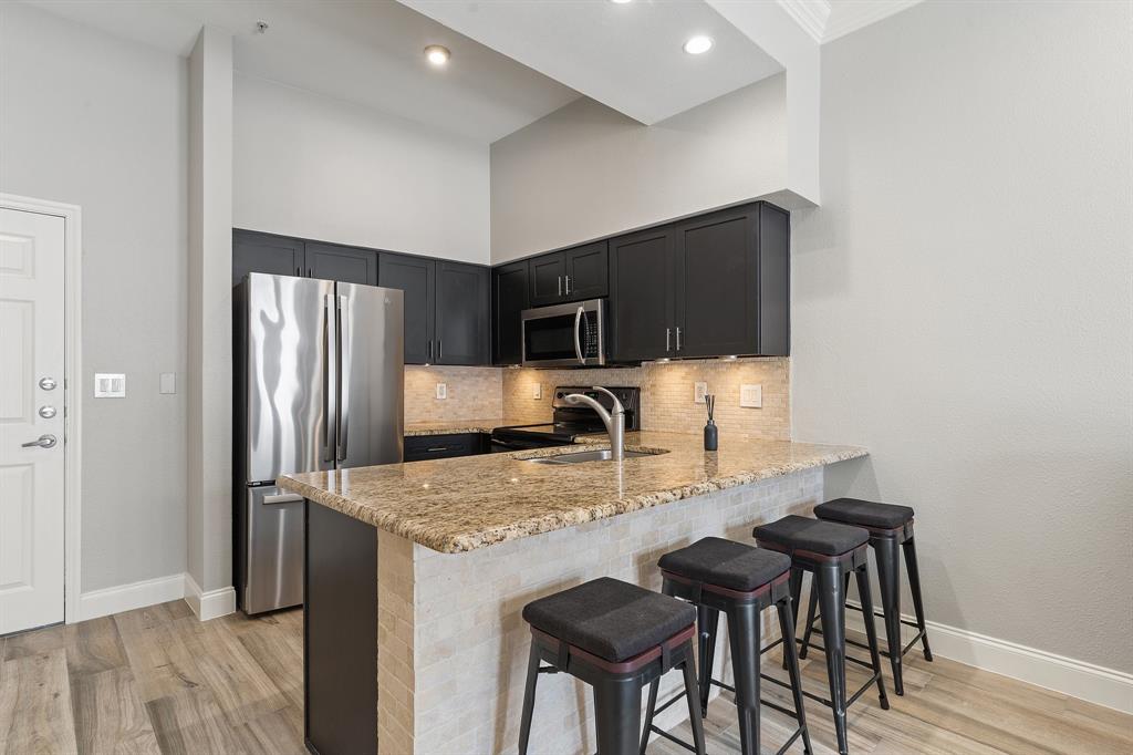 3102 Kings Road, Unit 1106 Dallas, TX 75219 - Photo 6 of 20 a kitchen with kitchen island a counter top space appliances and cabinets