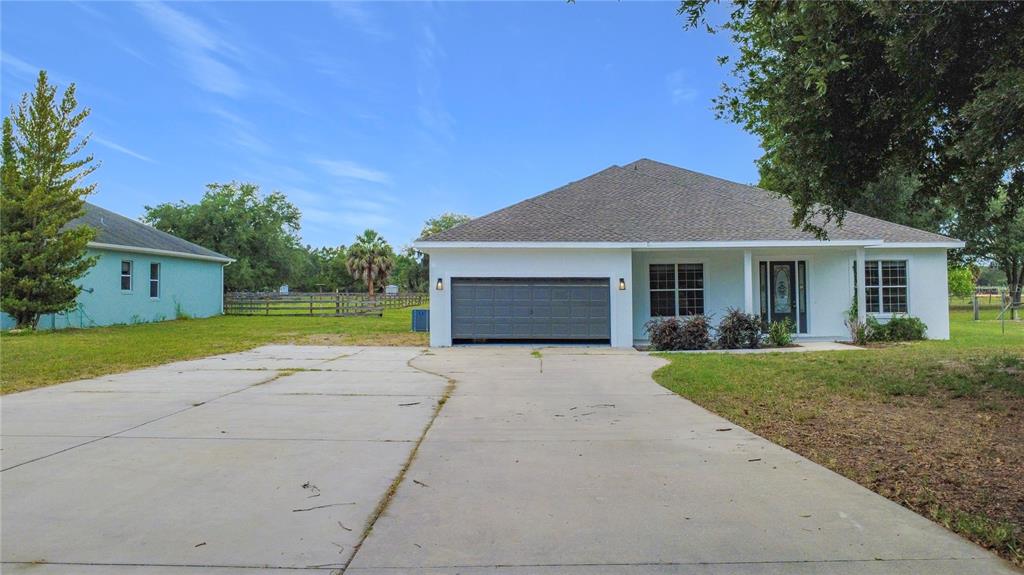 28549 Shirley Shores Road Tavares, FL 32778 - Photo 6 of 65 a front view of a house with a yard and garage