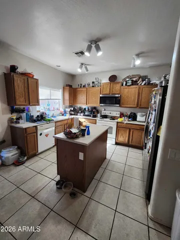 a large kitchen with granite countertop a stove a sink dishwasher and a refrigerator
