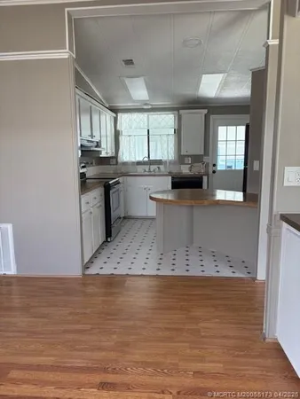 a view of kitchen island with stainless steel appliances granite countertop refrigerator sink and stove