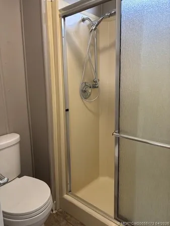 a white toilet sitting next to a shower