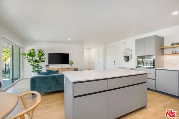 a living room with stainless steel appliances kitchen island furniture and a fireplace
