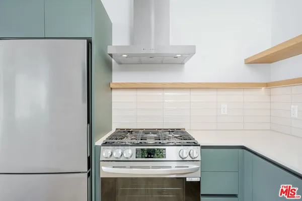 a stove top oven sitting inside of a kitchen