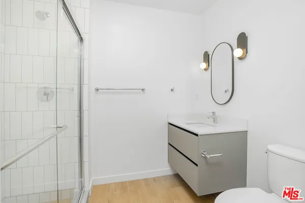 a bathroom with a granite countertop sink a toilet and a mirror