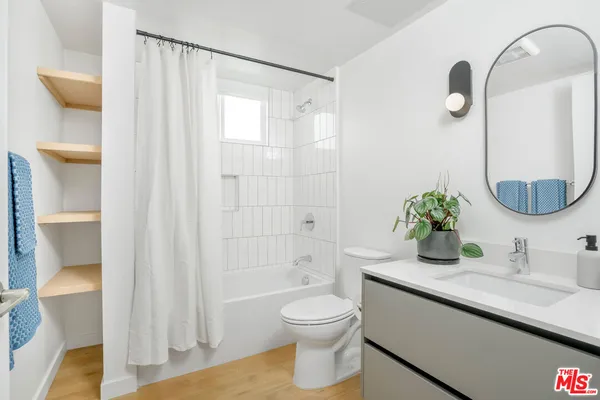 a bathroom with a granite countertop sink a toilet and shower