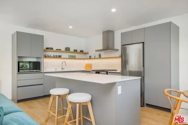 a kitchen with stainless steel appliances a refrigerator and a stove top oven