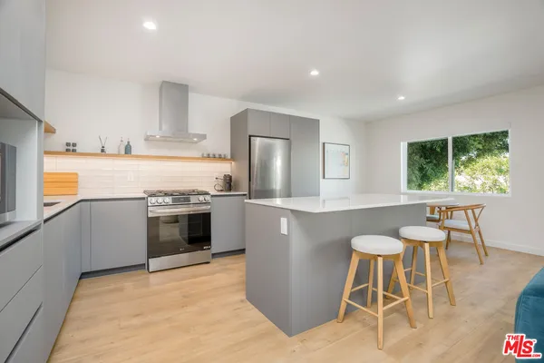 a kitchen with a stove a sink a counter top space and appliances