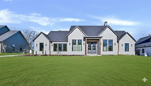 a front view of a house with a garden and trees