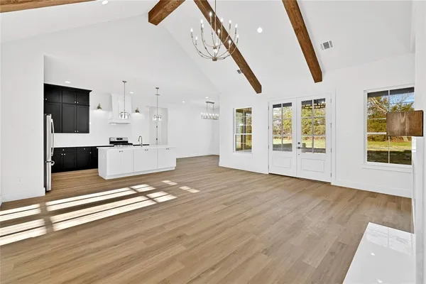 a view of empty room with wooden floor and windows
