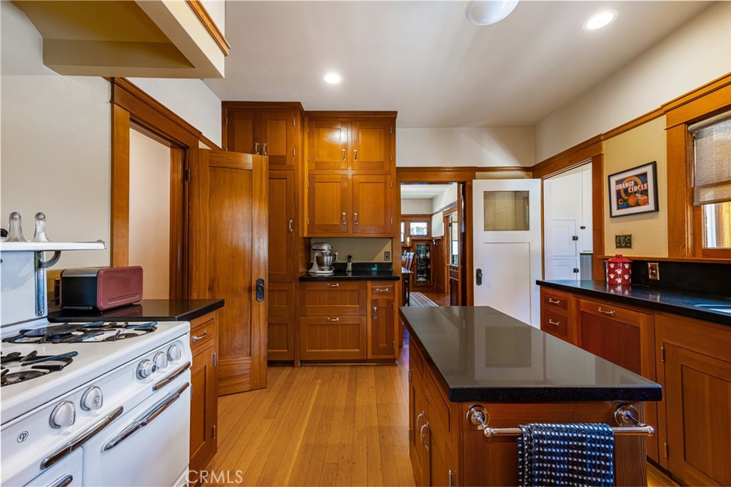 155 North Cleveland Street Orange, CA 92866 - Photo 14 of 39 a kitchen with stainless steel appliances granite countertop a stove top oven a sink dishwasher a dining table and chairs with wooden floor