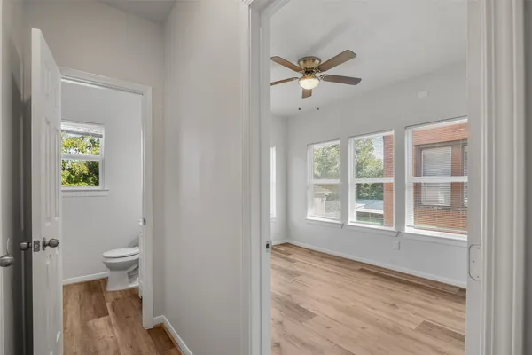a view of an empty room with a window and wooden floor