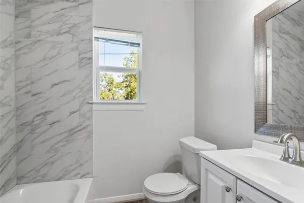 a bathroom with a toilet a sink and mirror