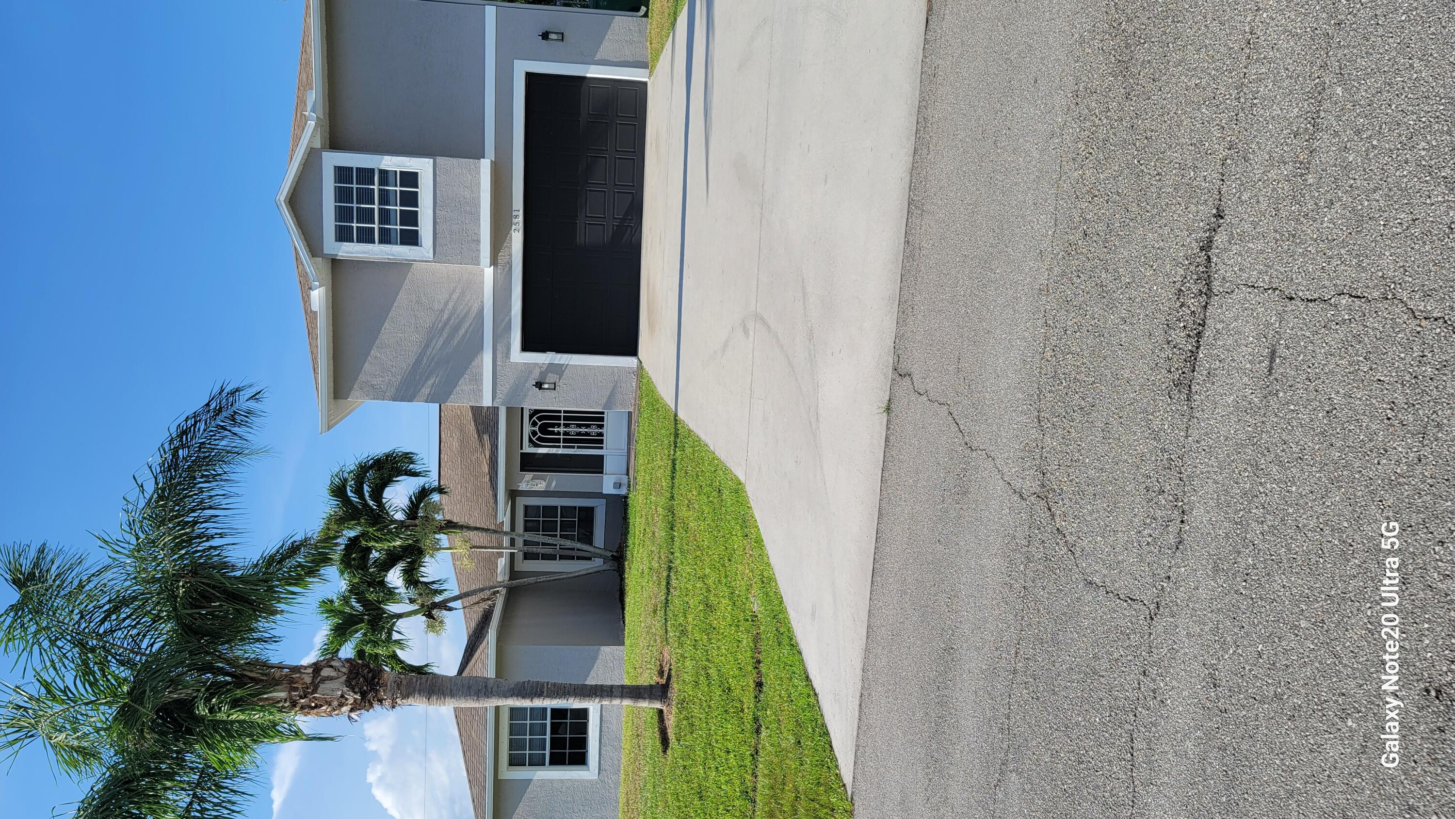 2581 Southeast Jason Avenue Port St. Lucie, FL 34952 - Photo 1 of 4 a front view of a house with a yard and garage