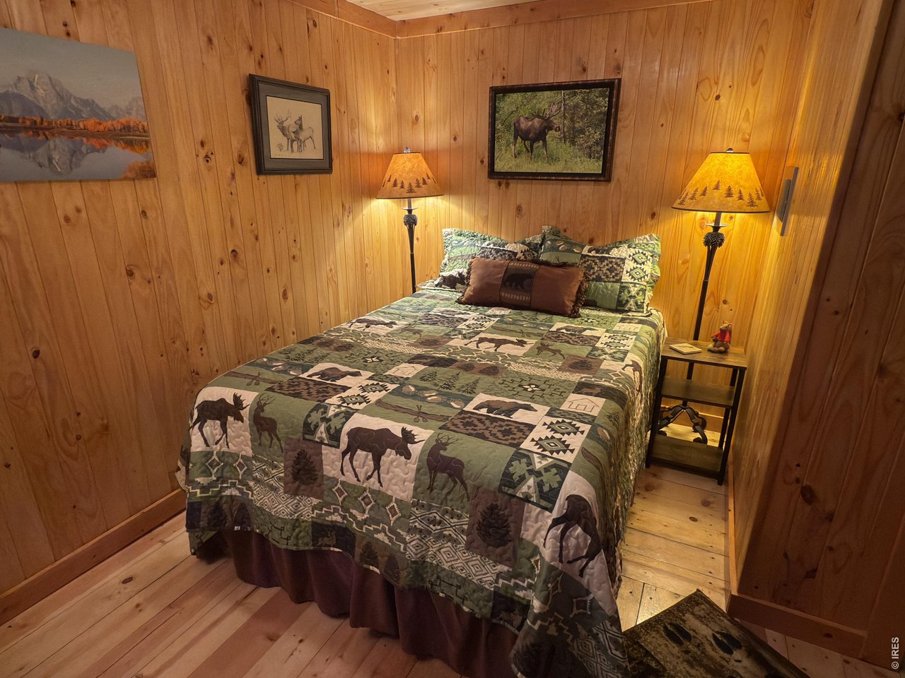 124 Ski Road Allenspark, CO 80510 - Photo 21 of 29 a bedroom with a bed and wooden floor