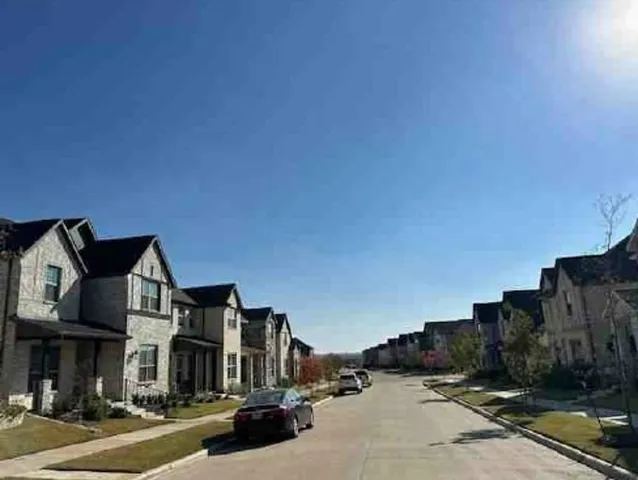 a front view of a building with streets and trees