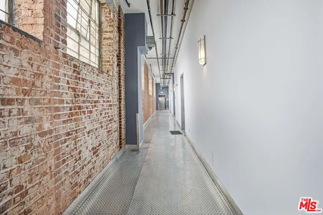 a view of a hallway with wooden floor and brick walls