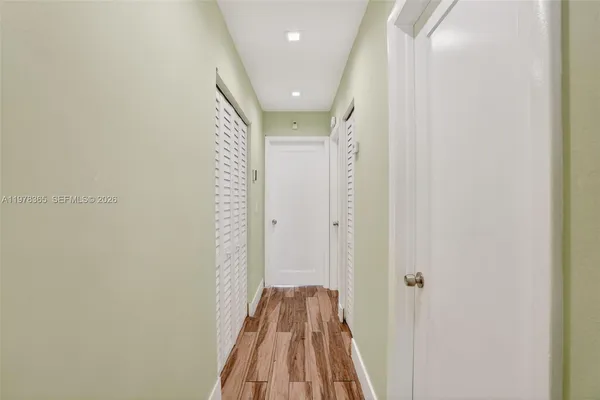 a view of a hallway with wooden floor and closet