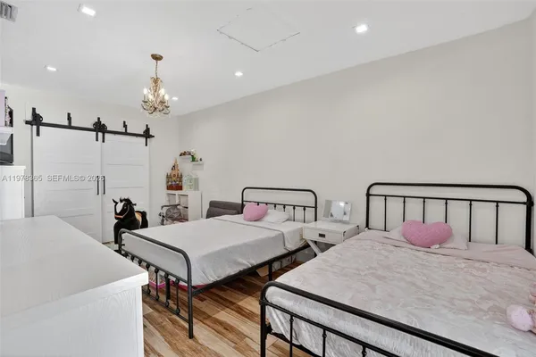 a bedroom with two beds and a chandelier