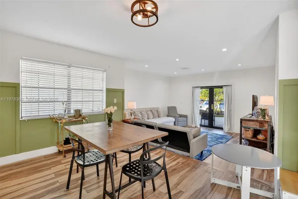 a view of a dining room with furniture a chandelier and wooden floor