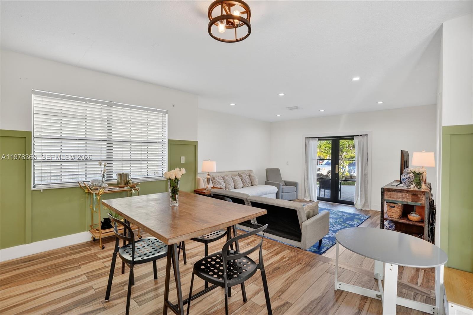 7016 Southwest 103rd Place Miami, FL 33173 - Photo 7 of 21 a view of a dining room with furniture a chandelier and wooden floor