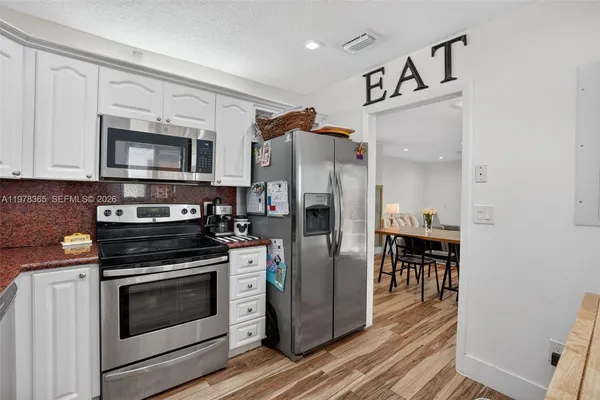 a kitchen with granite countertop a refrigerator stove and microwave
