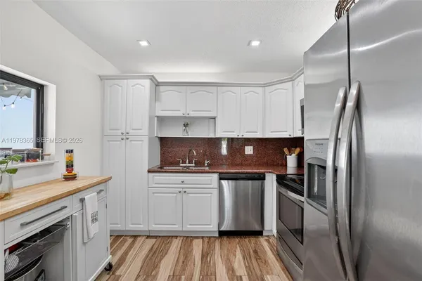 a kitchen with stainless steel appliances a sink stove and refrigerator