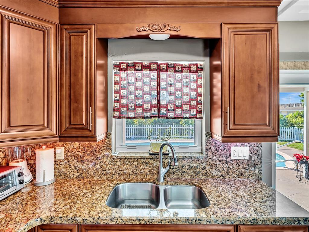 5180 Southwest 13th Street Plantation, FL 33317 - Photo 20 of 54 a kitchen with granite countertop a sink and a window
