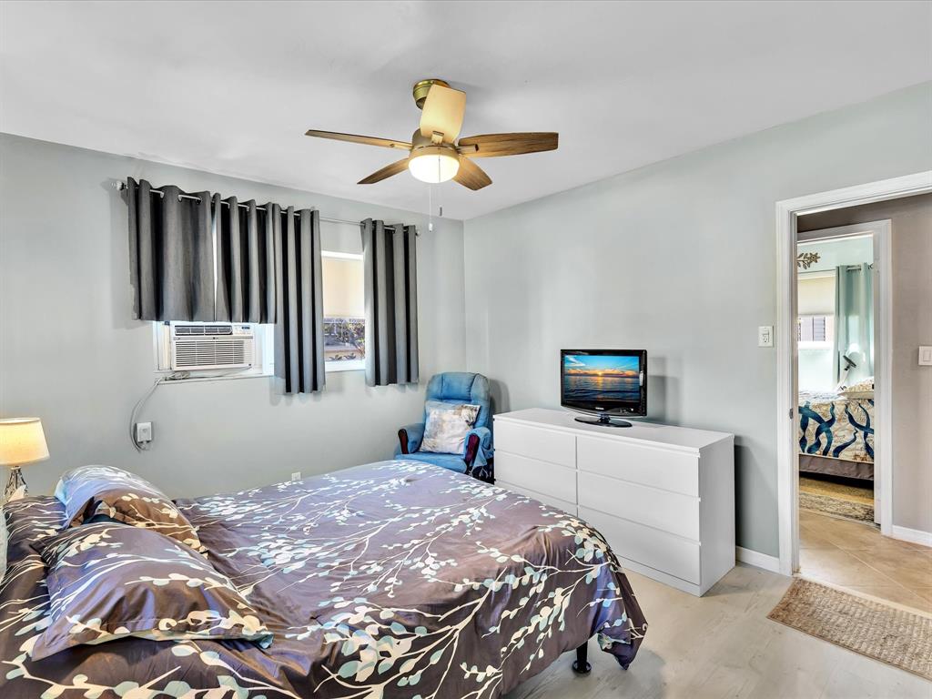 5180 Southwest 13th Street Plantation, FL 33317 - Photo 23 of 54 a bedroom with a bed and a chandelier