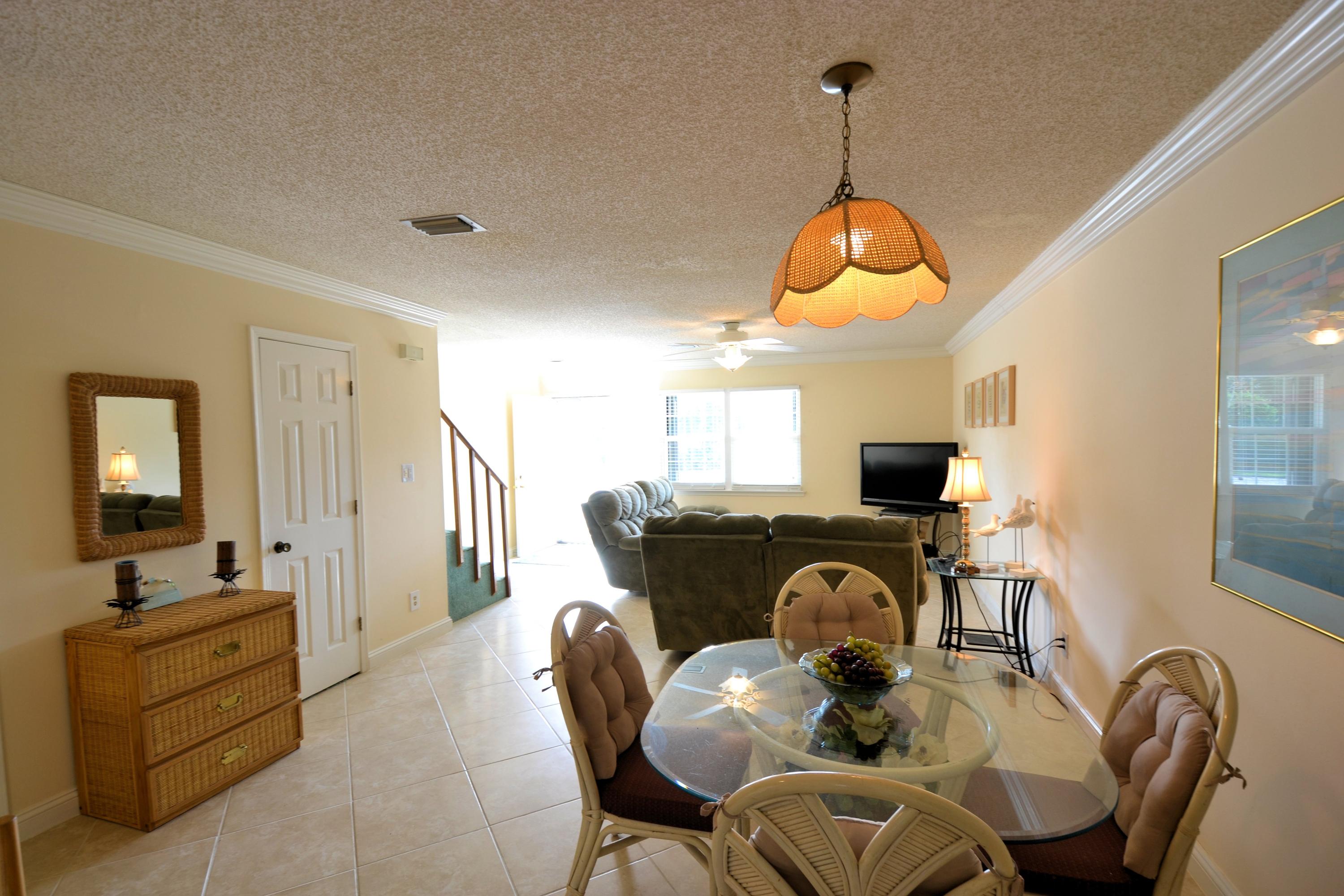 241 Ellis Road, Unit 29 Miramar Beach, FL 32550 - Photo 4 of 19 a living room with furniture a flat screen tv and kitchen view