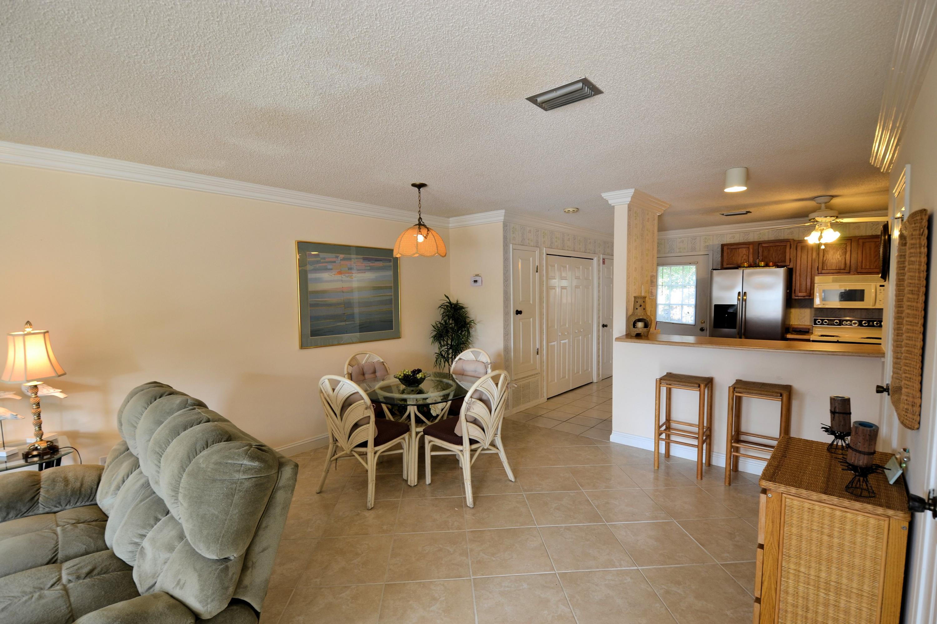 241 Ellis Road, Unit 29 Miramar Beach, FL 32550 - Photo 5 of 19 a living room with furniture a dining table and kitchen view