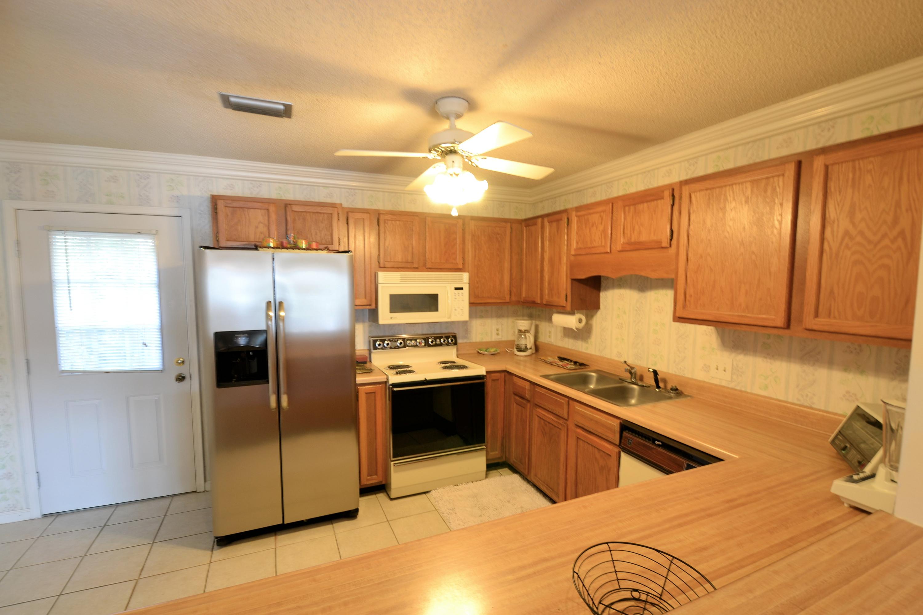 241 Ellis Road, Unit 29 Miramar Beach, FL 32550 - Photo 6 of 19 a kitchen with stainless steel appliances granite countertop a sink a stove a refrigerator cabinets and island