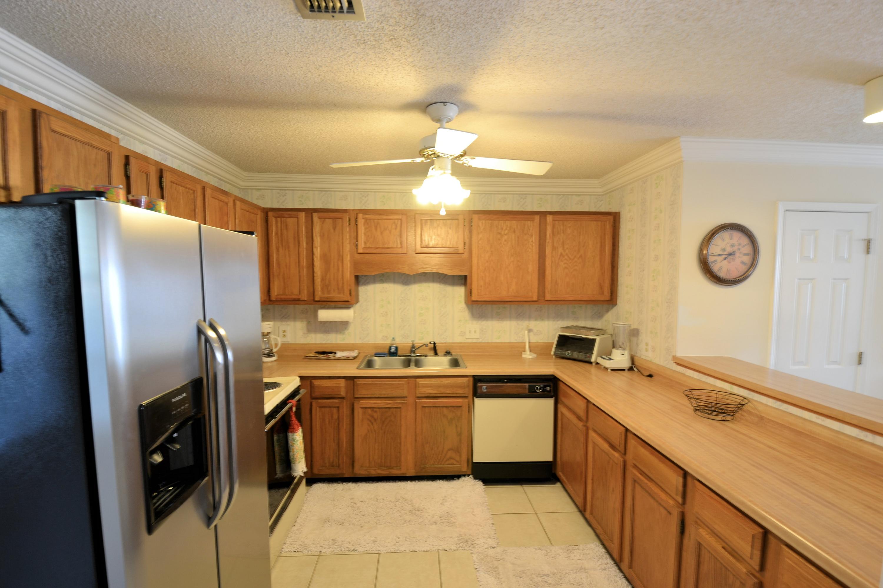 241 Ellis Road, Unit 29 Miramar Beach, FL 32550 - Photo 7 of 19 a kitchen with a sink a counter space cabinets and stainless steel appliances